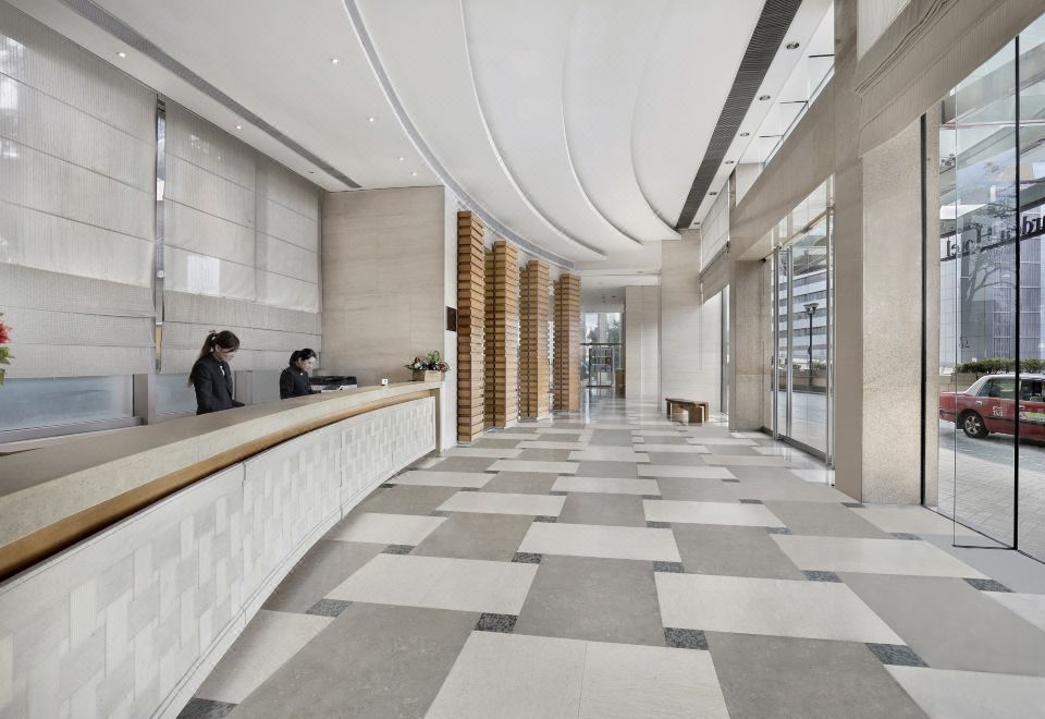 The lobby at Person's in Paris features a spacious window and a ceiling adorned with wooden panels at Rambler Oasis Hotel