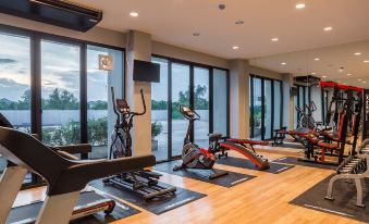 a well - equipped gym with various exercise equipment , including treadmills and weight machines , near large windows that offer views of the outdoors at Grand Inter Hotel