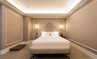 a large bed with white linens is in a room with beige walls and ceiling at Hengxing Mercure Hotel