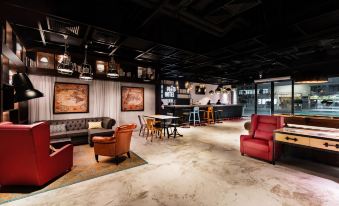 There is a room with tables and chairs in the middle, adjacent to an open concept kitchen with a dining area at Pentahotel Hong Kong, Tuen Mun
