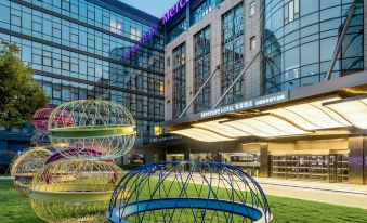 The large building features a centrally located outdoor seating area adorned with decorated tables at Mercure Shanghai Hongqiao SOHO