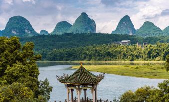 a picturesque scene of a river surrounded by mountains , with a gazebo and a temple in the background at Riverview Hotel