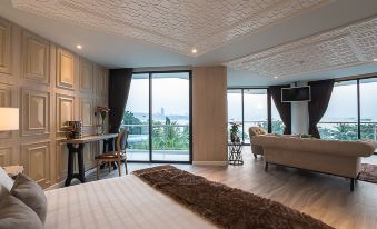 The spacious bedroom features floor-to-ceiling windows and a balcony that offers a stunning view of the city at night at Mera Mare Pattaya