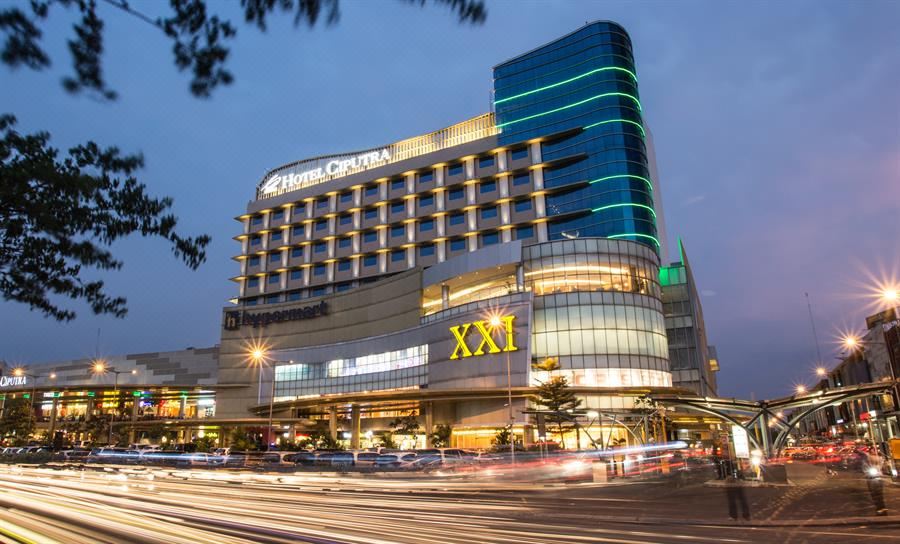 "a large hotel building with the name "" hyatt capital "" lit up at night , surrounded by cars on a city street" at Hotel Ciputra Cibubur Managed by Swiss-Belhotel International