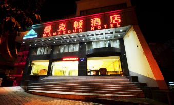 The hotel's front entrance is illuminated by neon lights at night, offering a view of the outside at Mankedun Hotel (Guangzhou Sanyuanli Metro Station)