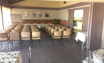 a large room with rows of chairs arranged in a semicircle , ready for a meeting or presentation at Lindy Lodge Motel