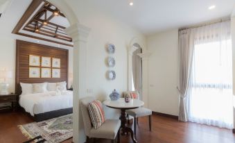 a cozy bedroom with a bed , a dining table , and a window overlooking the city at Content Villa Chiangmai