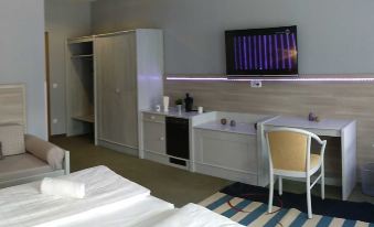 a modern hotel room with a bed , desk , and tv , as well as a bed with white sheets at Hotel Brunnenhof