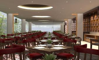 a modern , minimalist restaurant with wooden tables and chairs , red cushions , and white plates , surrounded by large windows and a wooden bar at Horison Gkb Gresik