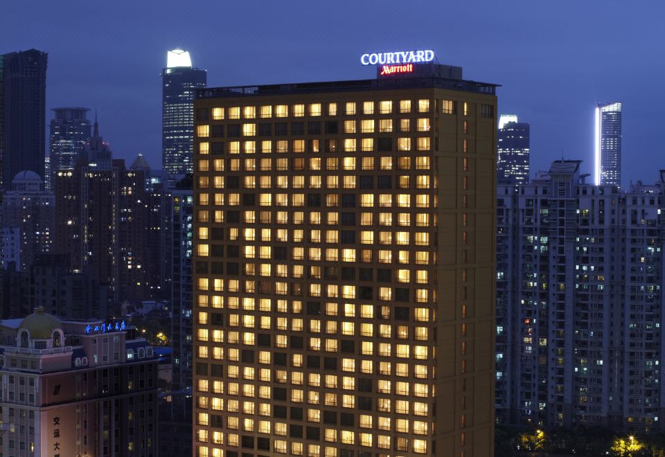 The city's skyline is illuminated with blue and white lights at night at Courtyard by Marriott Shanghai Central