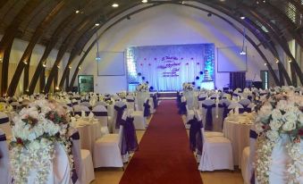 a long banquet hall with tables set up for a formal event , possibly a wedding reception at Indochine Hotel