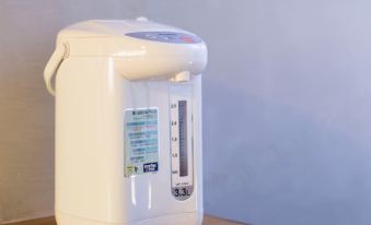A white blender sits on the table next to an empty water dispenser at Check Inn HK
