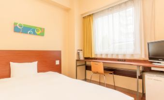 a hotel room with a single bed , a desk , and a window , all decorated in white at Chisun Inn Munakata