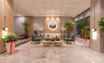 A spacious lobby or reception area in Hotel Brussels with tables and chairs at Yiwu Mankalan Hotel (International Trade City Xinguanghui Branch)