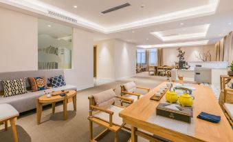 A spacious living area is furnished with couches, chairs, and tables at Ceramik Hotel (Foshan Lecong Furniture City)