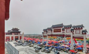 a large parking lot filled with numerous cars and trucks , with a building in the background at Spring Hotel