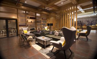 The living room features couches and chairs arranged in the center, complemented by an open concept design at Dreamer Hotel (Shanghai Hongqiao Airport, National Exhibition Center)