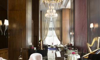 An elegantly decorated room with large windows, chairs, and tables in the center at The Langham, Shenzhen