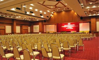 a large conference room with rows of chairs arranged in a semicircle , ready for an event at Rimpao Hotel