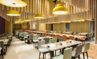 a large dining room with many tables and chairs , some of which are occupied by people at Okada Manila