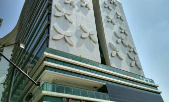 a tall building with a white facade and a glass window , featuring intricate designs on its exterior at Best Western Premier la Grande Hotel