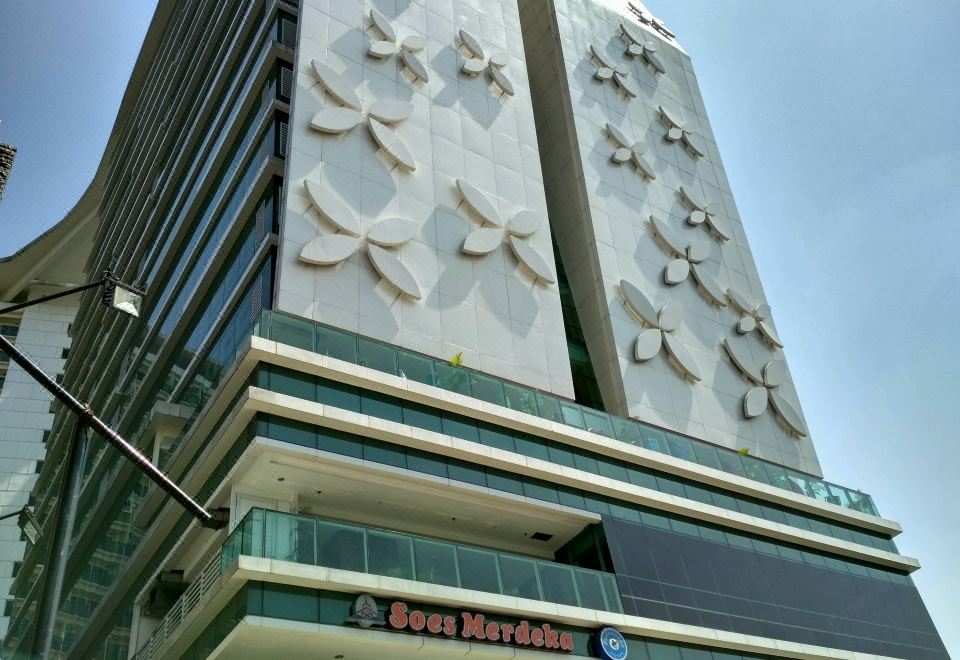 a tall building with a white facade and a glass window , featuring intricate designs on its exterior at Best Western Premier la Grande Hotel