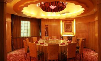 An elegantly designed room with round tables and chairs set for four people in the center at Jinghu Hotel