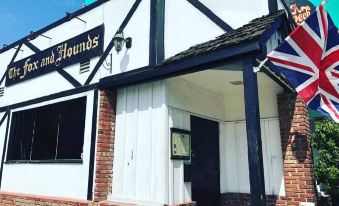 "a white building with a sign that says "" channel hounds "" and an american flag hanging from it" at The Fox & Hounds