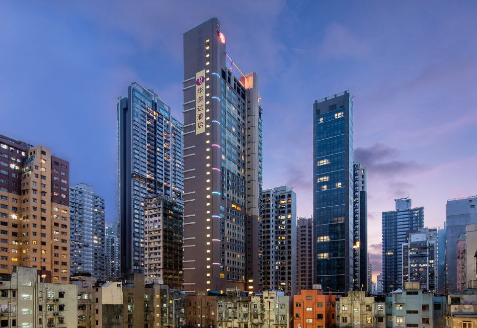 A cityscape of towering buildings with illuminated windows during dusk or nighttime at Ramada Hong Kong Harbour View