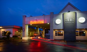 a carpinteria hotel entrance at night , with red lights illuminating the area and a red line leading to the hotel at Garden Hotel