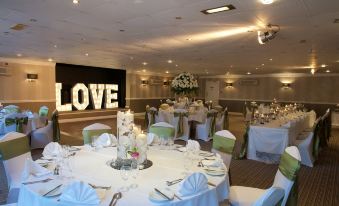 "a large room with a "" love "" sign on the wall and tables set up for a wedding reception" at Fairways Lodge & Leisure Club