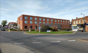 a brick building with multiple floors and windows , situated on the corner of a street at Premier Inn Felixstowe Town Centre