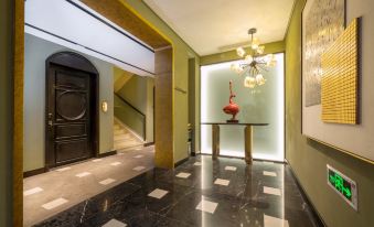 There is a hallway with doors and a table in the middle, adjacent to an entrance that leads to the hotel lobby, where guests can check in and access amenities at Huaihai Mansion