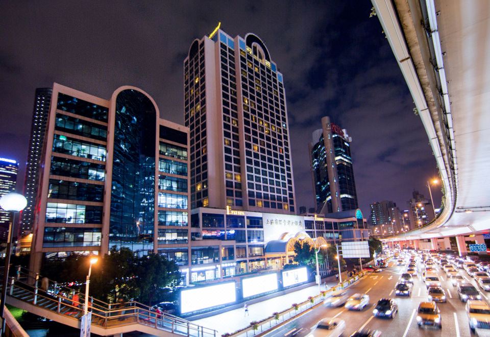 A city illuminated by blue and white lights at night at Hotel Equatorial Shanghai