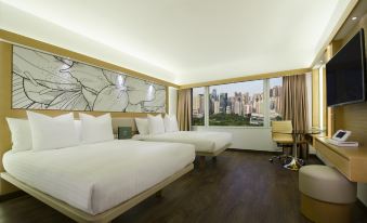 A bedroom with double beds and large windows offering city views at The Park Lane Hong Kong a Pullman Hotel