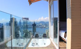 The bedroom is located next to a large balcony with an ocean view, which also overlooks another room at Best Western Hotel Causeway Bay