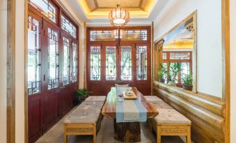 a dining room with a long wooden table , surrounded by chairs , and a mirror hanging on the wall at Riverview Hotel