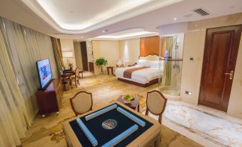 The large room features a bed, table, and chairs in the living area adjacent to the bedroom at Longyou International Grand Hotel