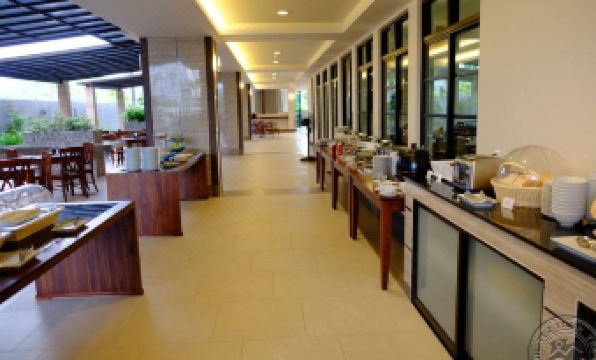 a large , well - lit restaurant with multiple dining tables and chairs , as well as various appliances and utensils at The Mangrove Hotel