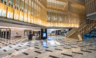 a modern building with a large lobby and a staircase leading to the second floor at bai Hotel Cebu