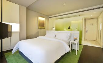 There is a large bed with a white and brown color scheme in the middle room at Jinjiang Metropolo Classiq Jing'An Hotel