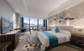 The modern bedroom features large windows that offer an outside view from the bed at Shenzhen Huaqiang Plaza hotel (Huaqiangbei Metro Station)