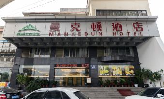 Cars pass by the front entrance of a restaurant and hotel in an Asian city at Mankedun Hotel (Guangzhou Sanyuanli Metro Station)