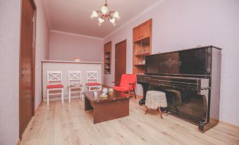 a living room with a wooden floor , pink walls , and a piano in the corner at Veranda