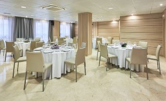 A spacious room is arranged with tables and chairs for events or formal dining at NH Logrono Herencia Rioja