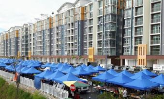 a large building with multiple blue tents set up in front , possibly for an event or gathering at G Residence