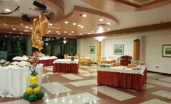 a large room with tables set up for a party , featuring red tablecloths and gold decorations at Hotel Astoria