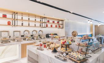 The restaurant has a variety of food options available on the table in front of it at Atour Hotel