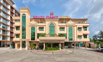 the grand palace hotel is a large , beige - colored building with a curved facade and green trees surrounding it at Grand Palace Hotel