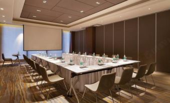 A spacious room is arranged with long tables and chairs for hosting events or meetings at Century Garden Hotel